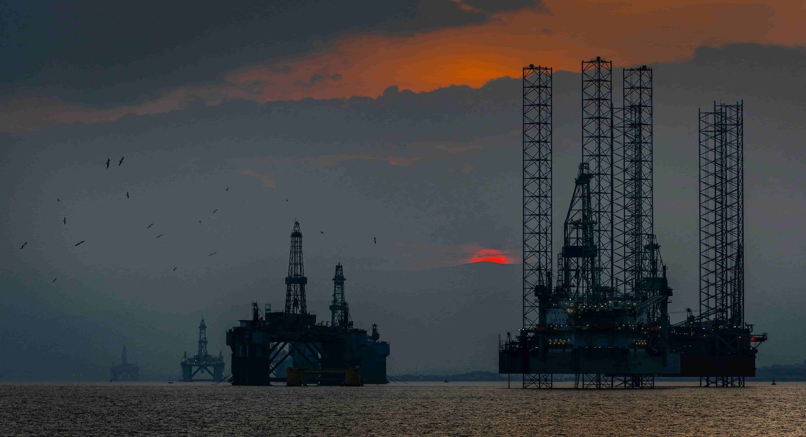 two oil rigs durin sunset